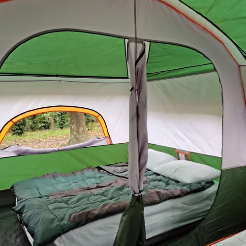 Interior da barraca com cama inflável, roupa de cama e travesseiros já montados